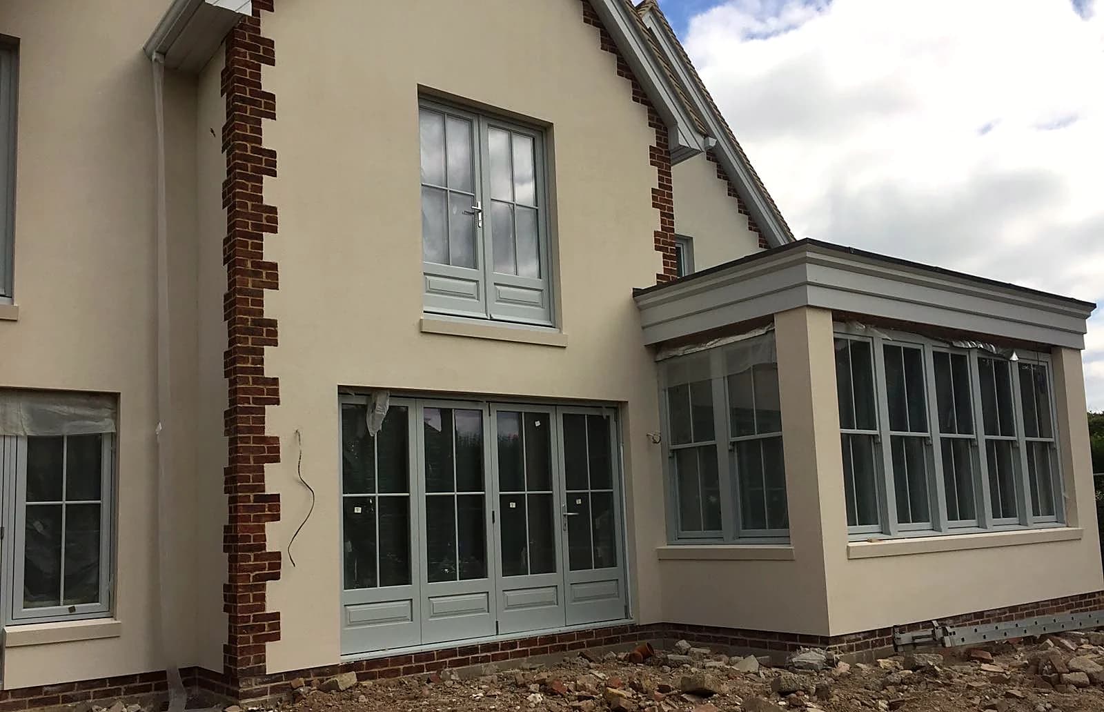 Bespoke new-build home with light grey timber sash windows and French doors